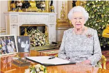  ??  ?? The Queen surrounded by family photos in her TV address