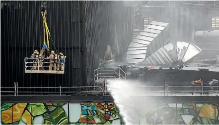  ?? DAVID WHITE/STUFF ?? Fire crews examine the damage to SkyCity Convention Centre while water is trained on the blaze.