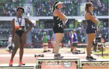  ?? Patrick Smith / Getty Images ?? U.S. hammer thrower Gwen Berry (left) turns from the flag and national anthem after her thirdplace finish Saturday.