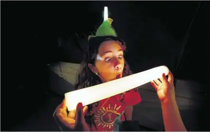  ?? MARK WEBER/THE COMMERCIAL APPEAL ?? Anjali Jackson Crater, 9, screams at a Light Baton, which lights up when feeling the vibrations of sound, during Camp Invention at Houston Middle School Friday afternoon. Students in the group were learning about wearable technology.