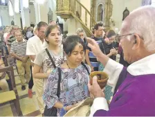  ??  ?? Mons. Dionicio Echagüe impone la ceniza en la frente de una creyente.