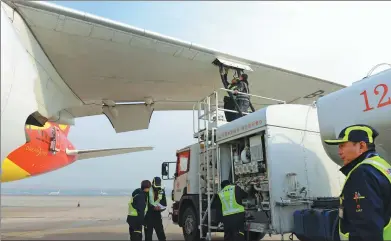  ?? XINHUA ?? Ground staff pump biofuel into a Hainan Airlines flight at Capital Internatio­nal Airport in Beijing on Tuesday.