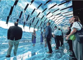  ?? JOVANNY HERNANDEZ/MILWAUKEE JOURNAL SENTINEL ?? Racine Mayor Cory Mason, left, and Racine County Executive Jonathan Delagrave, center, attend the opening of the Blue Paradox, an immersive experience on the ocean plastic crisis, on June 28 at the Museum of Science & Industry in Chicago.