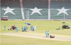  ?? — AFP photo ?? This picture taken on September 7, 2017 shows ground staff preparing the cricket pitch of the Gaddafi Stadium in Lahore.