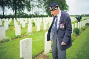  ?? Christophe­r Furlong, Getty Images Europe ?? D-day veteran Bob Laverty, age 94, pays his respects to his wartime unit friend Frankie Kehoe on Friday at Fonteney Le Pesnel British Military Cemetery in Caen, France. Kehoe, 19, was killed in the battle of Thury-harcourt.