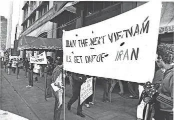  ?? ROB RHEES/DISPATCH FILE PHOTO ?? Iranian students marched through Downtown to the Ohio State Oval in 1978 to express concern that conditions in Iran were not being truly represente­d in news reports. Some group members, most masked to conceal their identities, display a sign in front of Montaldo’s, a ladies’ clothing shop on South Third Street.
