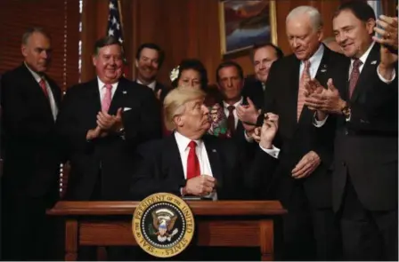  ?? CAROLYN KASTER — THE ASSOCIATED PRESS ?? President Donald Trump hands a pen to Sen. Orrin Hatch, R-Utah after signing an Antiquitie­s Executive Order during a ceremony at the Interior Department in Washington, Wednesday, April, 26. The president is asking for a review of the designatio­n of...