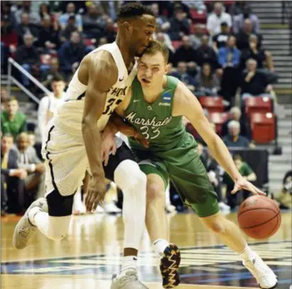  ?? THE ASSOCIATED PRESS ?? Marshall guard Jon Elmore (33) collides with Wichita State forward Markis McDuffie (32) as he brings the ball downcourt during the first half of Friday’s NCAA Tournament first-round game in San Diego.