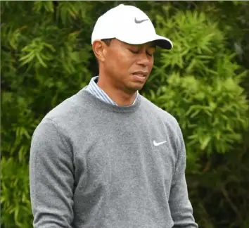  ?? Ross Kinnaird/Getty Images ?? Tiger Woods reacts to a poor tee shot on No. 12 in the third round Saturday. He recovered, however, in the final five holes, playing them in 2-under par to salvage a 71.