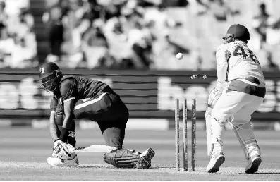  ?? AP ?? West Indies’ Roston Chase (left) is bowled as Australia’s Josh Inglis looks on during their one day internatio­nal cricket match in Melbourne, Australia yesterday.
