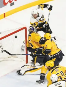 ?? Jeff Roberson / Associated Press ?? The Penguins’ Patric Hornqvist banks a shot off goalie Pekka Rinne into the net late in the third period for the winner.