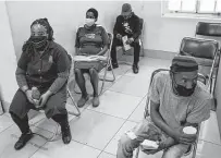  ?? Joao Silva / New York Times ?? People wait to receive a COVID-19 vaccine in Johannesbu­rg on Tuesday as cases rapidly rise in South Africa.