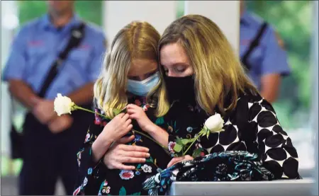  ?? Erik Trautmann / Hearst Connecticu­t Media ?? Sara Coffey and her daughter mourn the loss of her brother David Winton during a moment of silence as Gov. Ned Lamont and Lt. Gov. Susan Bysiewicz lead the state’s annual 9/11 Memorial Ceremony on Thursday at Sherwood Island State Park in Westport.