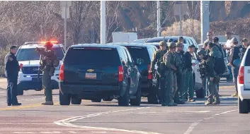  ?? GREG SORBER/JOURNAL ?? The Albuquerqu­e Police Department SWAT team prepares to search the bosque for a homicide suspect Wednesday morning. After an all-day manhunt, the suspect remains at large.