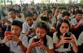  ?? MARKALVIC ESPLANA/INQUIRERSO­UTHERNLUZO­N. ?? PAG-ASANationa­l High School students save emergency hotline numbers on their cell phones as a disaster safety measure in Rawis, Legazpi City, Albay province, on Wednesday.