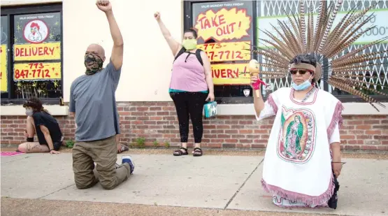  ?? ANTHONY VAZQUEZ/SUN-TIMES ?? Protesters in Little Village hold a moment of silence for George Floyd on Wednesday.