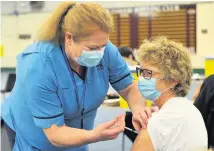  ??  ?? Delighted Sheila West receives her first dose of the vaccine