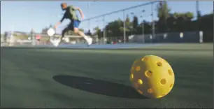  ?? Courtesy Stan Lim; The Orange County Register ?? A whiffle ball rests on the court as people play pickleball. Groups of players are mobilizing nationwide, trying to get permission to expand the sport in their hometowns and cities.