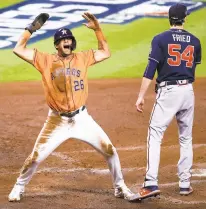  ?? KEVIN M. COX/AP ?? Houston’s Jose Siri celebrates next to Atlanta Braves starting pitcher Max Fried after scoring on a throwing error during the second inning in Game 2 of the World Series on Wednesday.