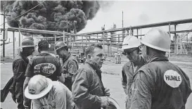  ?? Houston Chronicle file ?? Red Adair, center, talks with workers from his “Red Adair Wild Well Control” team at a 1965 fire in Baytown.