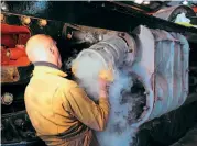  ??  ?? Above: One of the biggest engineerin­g tasks on Pendennis Castle's restoratio­n, apart from the boiler, was relining the valves and cylinders, work which was contracted to Bryn Engineerin­g of Wigan. In December 2010, John Marrow and Duncan Ward, of Bryn Engineerin­g, were at Didcot Railway Centre to clean and measure the valve and cylinder castings on the locomotive, before machining to size the liners, which had already been cast, and later returning to shrink fit them. Duncan is seen here pushing the front valve liner into the left-hand outside cylinder of No. 4079, after it had been shrunk in liquid nitrogen. FRANK DUMBLETON