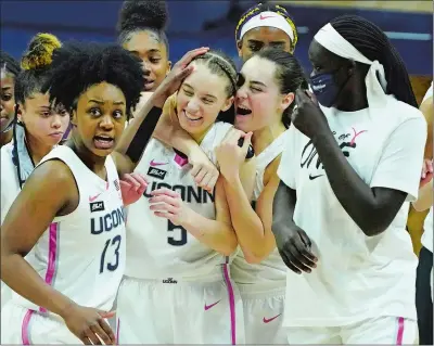 ?? DAVID BUTLER/POOL PHOTO/AP PHOTO ?? UConn guard Nika Muhl (10) hugs guard Paige Bueckers (5) after defeating South Carolina in overtime in Monday’s game at Gampel Pavilion in Storrs. Bueckers scored 31 points as No. 2 UConn beat No. 1 South Carolina 63-59.
