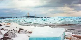  ??  ?? Blue ice is piled Monday on Lake Huron at the Straits of Mackinac, with the Mackinac Bridge as a backdrop. TORI BURLEY