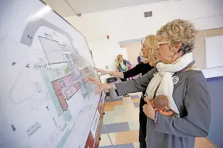  ??  ?? President and United Way CEO Katherine Freeman, front, and Valerie Plame Wilson, keynote speaker and a United Way board member, look at the plans during Tuesday’s open house for a preschool center at the vacant Kaune Elementary School.