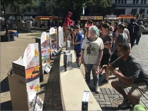  ?? MICHAEL FITZPATRIC­K — THE MORNING JOURNAL ?? People look at art contest entries at Elyria Apple Festival Sept. 19at Ely Square in Elyria.