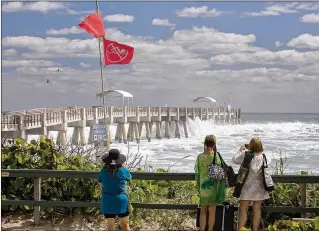  ?? ALLEN EYESTONE / THE PALM BEACH POST ?? Waves pummel the Lake Worth Pier on March 5, tearing off floorboard­s and damaging the lighting system. A full moon, higher than usual tides and the brutal winter storm that pounded the Northeast delivered a powerful punch comparable to hurricanes Irma...