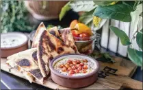  ?? ?? Ela offers three hummus options, including this one featuring crispy chickpeas and sumac. The trio also is available as a $15 sampler, with grilled pita. An extra order of pita is $4 a pop.