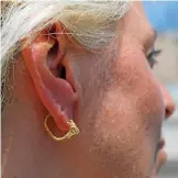  ??  ?? Professor Cayetana Johnson wears a rare golden earring believed to be more than 2,000 years-old, discovered at the archeologi­cal site of the City of David in East Jerusalem.