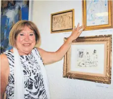  ?? FOTO: SUSI WEBER ?? Vorsitzend­e Gisela Löchner neben Bildern eines Künstlers aus der Region, der unter dem Pseudonym „Paul Picasso“seine Werke ausstellt. Neben „Paul Picasso“sind in der Ausstellun­g „Nackte Tatsache“noch Werke von 17 weiteren Künstlern zu sehen.