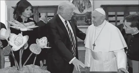  ?? ALESSANDRA TARANTINO, POOL/AP PHOTO ?? Pope Francis exchanges gifts with President Donald Trump and first lady Melania Trump, on the occasion of their private audience, at the Vatican on Wednesday.