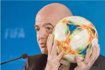  ?? — AFP ?? Fifa President Gianni Infantino holds a ball while speaking at a press conference during the football federation’s Council meeting in Shanghai on Thursday.