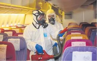  ?? VARUTH HIRUNYATHE­B ?? A worker wearing protective clothing cleans the cabin of a Thai Airways jet. Airlines must adapt to new customer expectatio­ns in the Covid era.