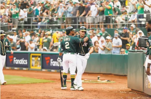  ?? Santiago Mejia / The Chronicle ?? The A’s Matt Chapman is congratula­ted by Khris Davis after a goahead home run in the eighth. Davis scored later in the inning.