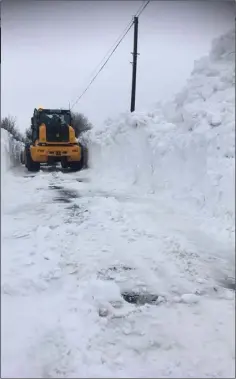  ??  ?? Machinery clearing a path through drifts in North Wexford.