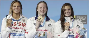  ??  ?? BUDAPEST: United States’ gold medal winner Lilly King is flanked by Russia’s silver medal winner Yuliya Efimova, left, and United States’ bronze medal winner Katie Meili, right, during the ceremony for the women’s 50-meter breaststro­ke final during the...