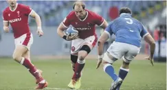  ??  ?? 0 Wales’ Alun Wyn Jones, centre, runs at Italy’s David Sisi