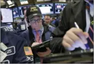  ?? THE ASSOCIATED PRESS ?? Trader Richard Cohen wears a “Dow 21,000” cap as he works on the floor of the New York Stock Exchange on Wednesday.