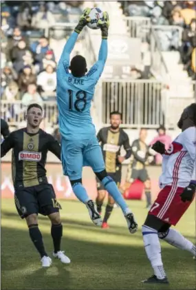  ?? CHRIS SZASGOLA — THE ASSOCIATED PRESS ?? The Union’s Andre Blake, center, leaps to catch the ball with Keegan Rosenberry, left, and Toronto FC’s Jozy Altidore, right, looking on admiringly Saturday at Talen Energy Stadium in Chester.