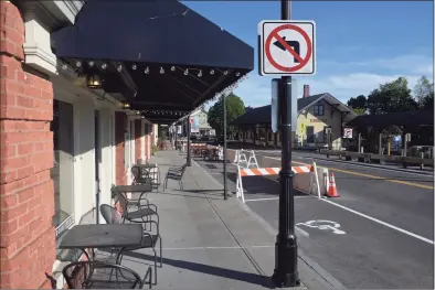  ?? H John Voorhees III / Hearst Connecticu­t Media file photos ?? A view of Railroad Street in New Milford, with restaurant tables set up for outdoor dining. Jersey barriers have been placed to extend the outdoor dining area.