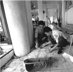  ?? — Reuters photo ?? Students clean up at a state-run high school following the earthquake in Palu, Central Sulawesi.