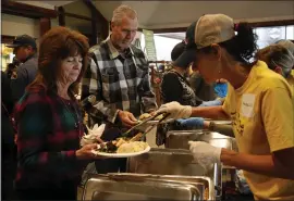  ?? KARL MONDON — STAFF PHOTOGRAPH­ER ?? Debbie and Mike Edgmon, homeless since the Camp Fire destroyed their home in Paradise two weeks ago, are served a Thanksgivi­ng meal by Natalie Cilurzo on Thursday at Sierra Nevada Brewing Co. in Chico.
