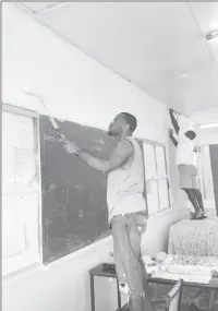  ??  ?? Randy Mingo, a trained graduate teacher, and colleague painting the classrooms of Bladen Hall Multilater­al “before” they went on strike.