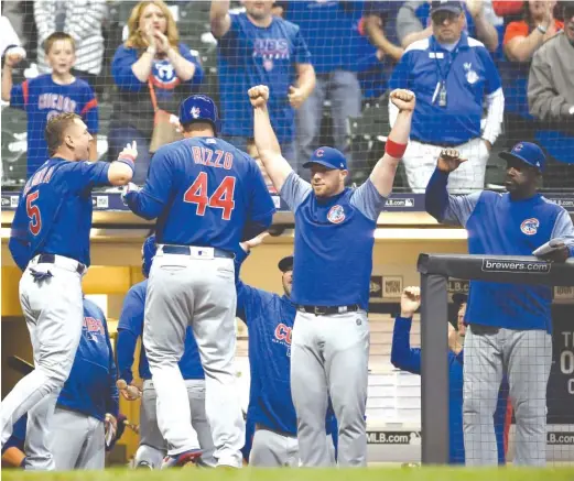  ?? STACY REVERE/ GETTY IMAGES ?? First baseman Anthony Rizzo receives a hero’s welcome after leading off the 11th inning with a first- pitch home run off Matt Albers.