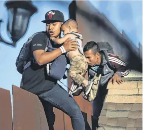  ?? PHOTOS: REUTERS/ CARLOS GARCIA RAWLINS/LEAH MILLIS ?? Desperate: Migrants attempt to cross from Mexico to the US, in Tijuana, Mexico, yesterday.