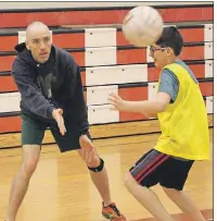  ?? MILLICENT MCKAY/TC MEDIA ?? CJ Studer, a phys-ed teacher at Athena Consolidat­ed School, makes a pass, despite Hunter Irving’s best efforts, during a Gaelic football drill.