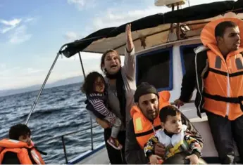  ?? ARIS MESSINI/AFP/GETTY IMAGES ?? Syrian Kurdish refugees were rescued by Greek fishermen after the boat they had boarded sunk in the Aegean Sea.